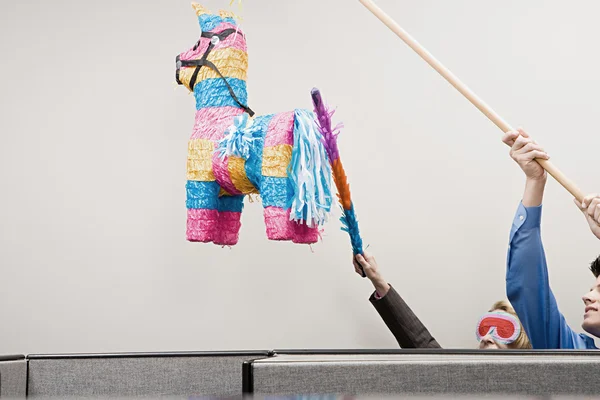 Office workers playing with a pinata — Stock Photo, Image