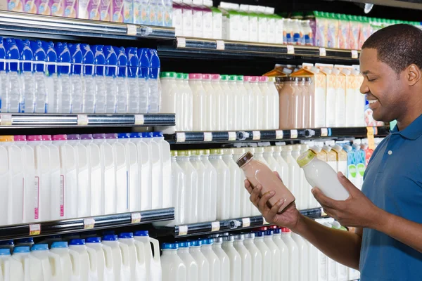 Šťastný muž s lahví v supermarketu — Stock fotografie