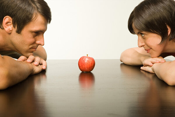 Apple on table between couple
