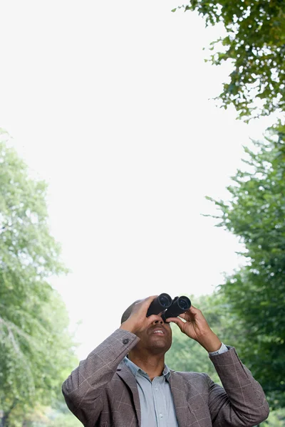 Man looking through binoculars — Stock Photo, Image