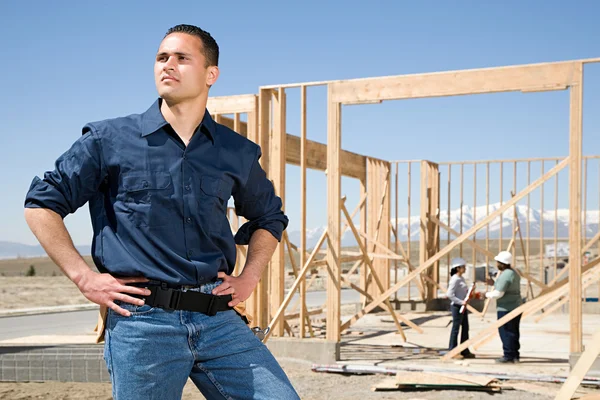 Portret van een bouwer in de buurt van de bouwplaats — Stockfoto