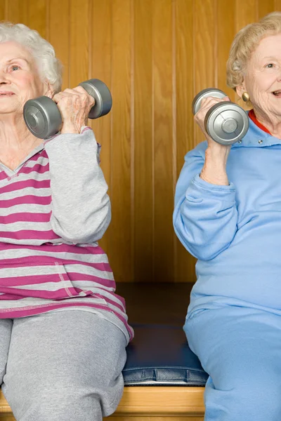 Duas mulheres idosas a levantar halteres — Fotografia de Stock