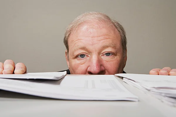 Mature man behind cabinet — Stock Photo, Image