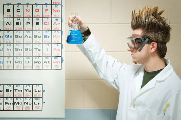 Male student holding up a chemical liquid — Stock Photo, Image