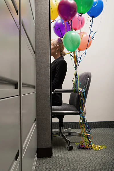 Businesswoman sat with bunch of balloons — Stock Photo, Image