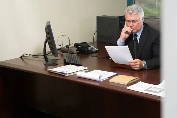 Affärsman behandlingen återupptas i office — Stockfoto