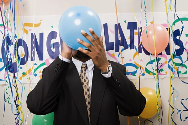 Businessman blowing up a balloon — Stock Photo, Image