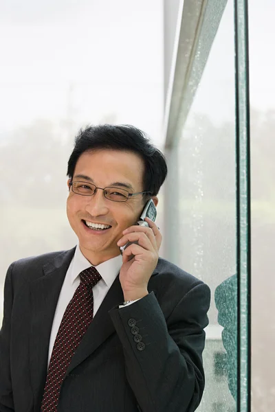 Empresário usando um telefone celular — Fotografia de Stock