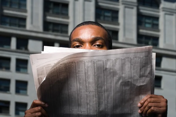 Man op zoek over krant — Stockfoto