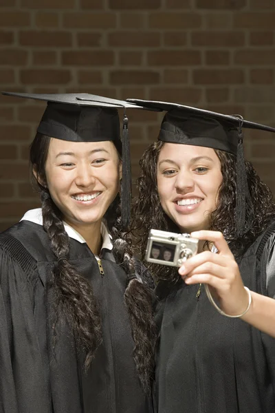 Twee vrouwelijke afgestudeerden een foto neemt — Stockfoto