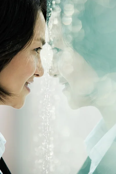 Chinese businesswoman with face to window — Stock Photo, Image