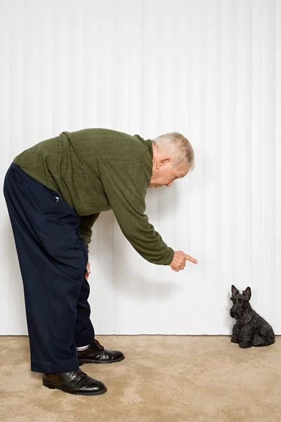 Oudere man wijzend op hond ornament — Stockfoto