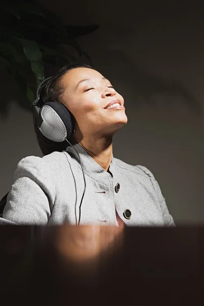 Business woman wearing headphones — Stock Photo, Image