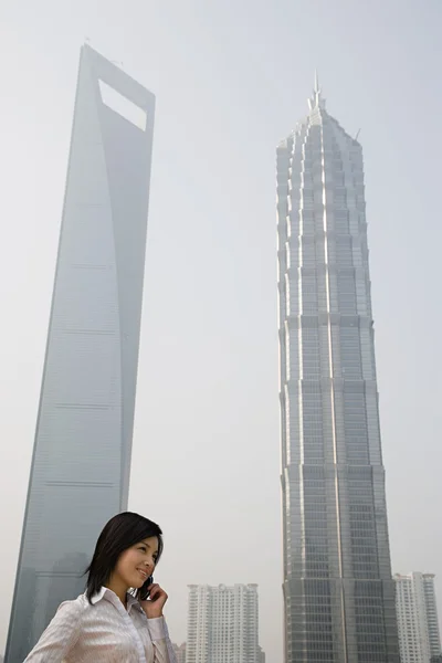 Chinese businesswoman near skyscrapers — Stock Photo, Image