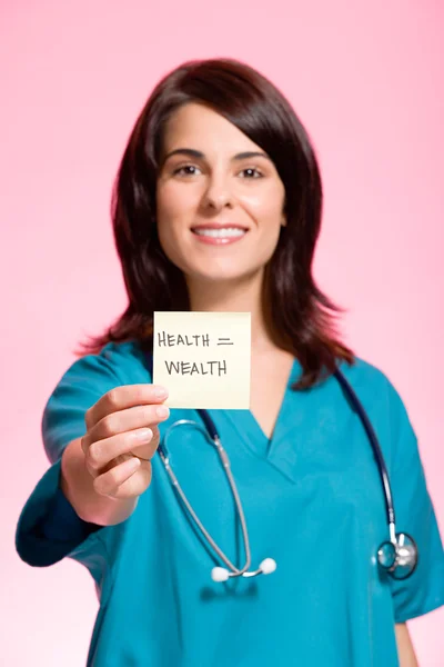 Женщина-медсестра держит клейкую ноту — стоковое фото