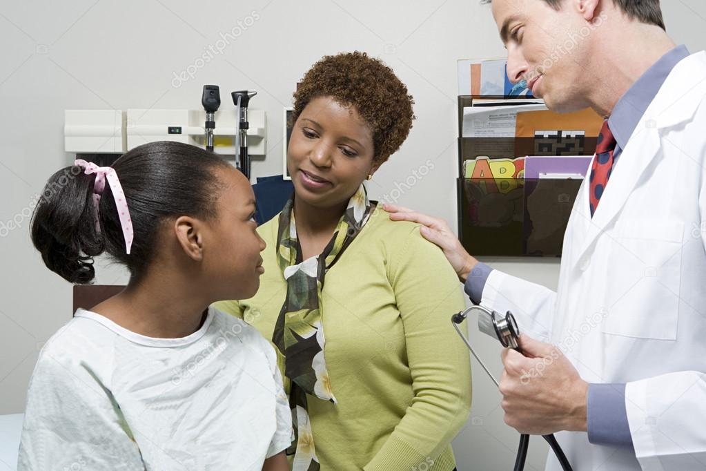 Doctor reassuring mother and daughter