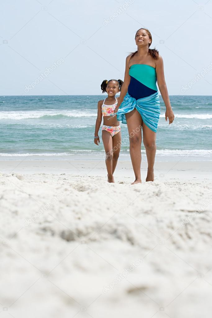 Mother and daughter walking on beach