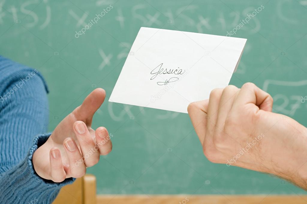 Boy passing girl a letter in class