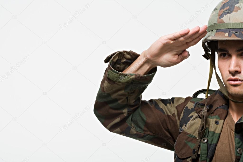 Male soldier in helmet saluting