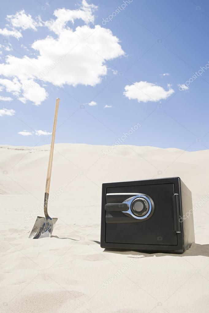 Safe and spade in desert