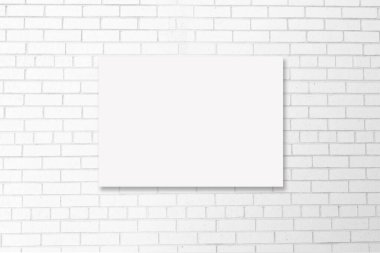 Modern beyaz tuğlalı bir duvarda, tuval etrafında kesme yolu olan A4 tuval yakın plan..