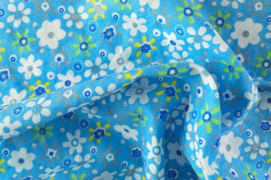 Eskimiş beyaz ve sarı çiçek desenli parlak açık mavi kumaş. El işi, yorgan dikme ya da moda tasarımı projeleri için ideal..