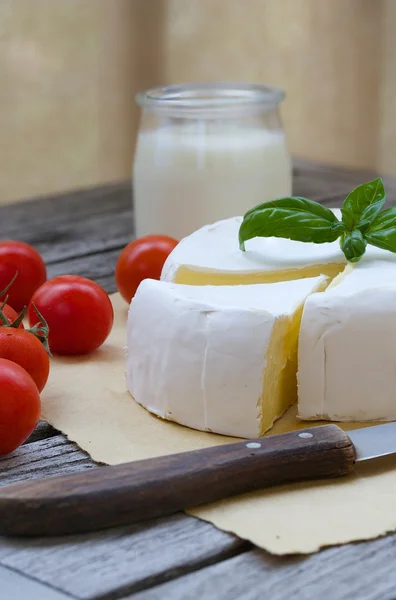 Вонючий французский сыр и красные помидоры черри. Крупный план — стоковое фото