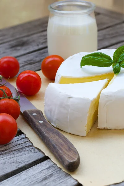 Queijo francês fedorento e tomates cereja vermelhos. Fechar. — Fotografia de Stock