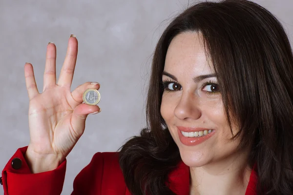 Una moneda de euro en la mano de una joven . — Foto de Stock