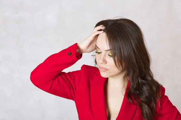 Een gestresste jonge vrouw in een rood klassieke kostuum — Stockfoto