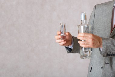 Alkol ve eller o içinde para ile bir cam şişe