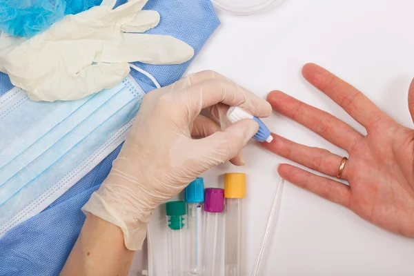 Lab technicus geldt een fingerprick. — Stockfoto