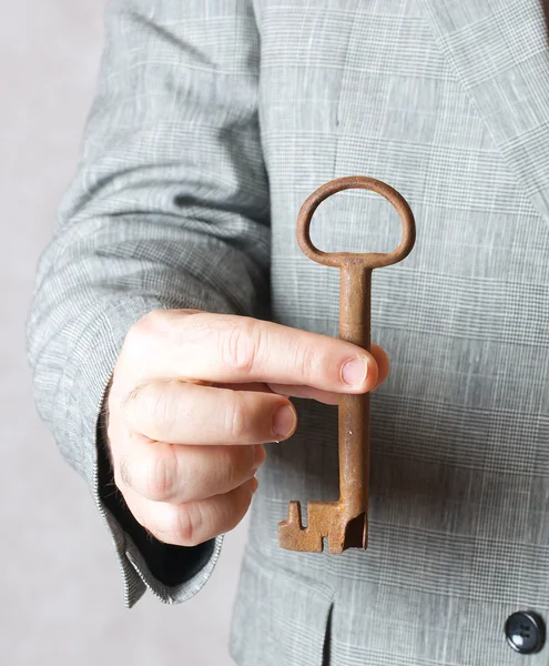 Bir adamın elinde eski bir anahtar. — Stok fotoğraf