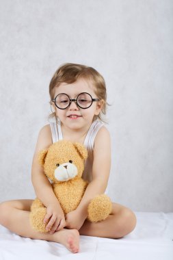 Üç yaşında çocuk kahverengi peluş oyuncak ayı ile