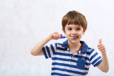 Bir çocuk dişlerini temizliyor