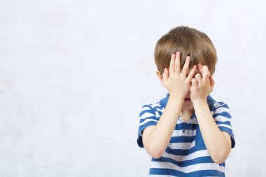 Bir çocuk bir palm ile yüzünü kapsar