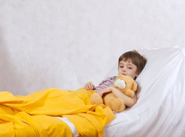 Bir çocuk hastane yatağında yatıyor.