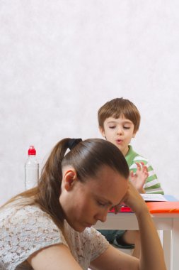 Yorgun bir anne ve onun homew yapmak zorunda olan altı yaşında çocuk
