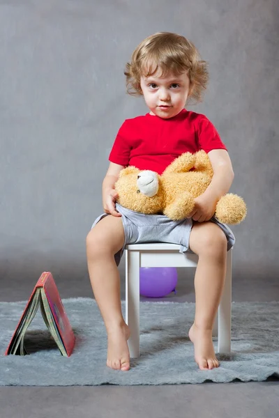 Трехлетний мальчик сидит на белом стуле . — стоковое фото