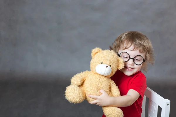 Un enfant de 3 ans joue avec un ours en peluche — Photo