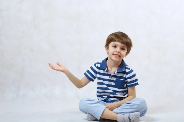 Een jongen blijkt iets met zijn hand — Stockfoto