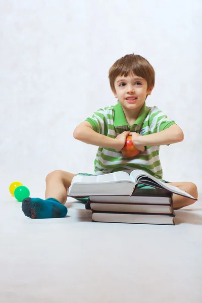 Chlapec s apple a hromady knih — Stock fotografie