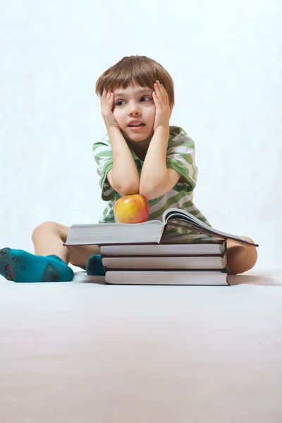 Мальчик и куча книг — стоковое фото