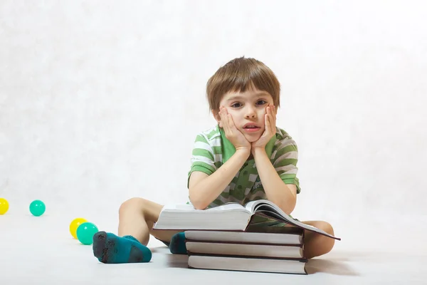 Мальчик и куча книг — стоковое фото