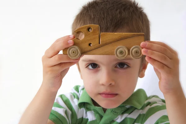 Een jongen toont zijn favoriete woodenmade speelgoed — Stockfoto