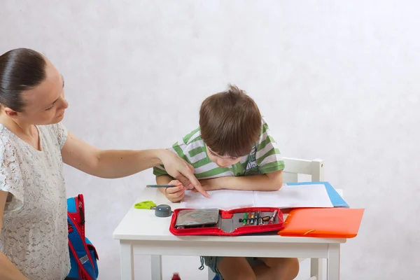 Die Mutter überprüft die Hausaufgaben ihres Sohnes — Stockfoto