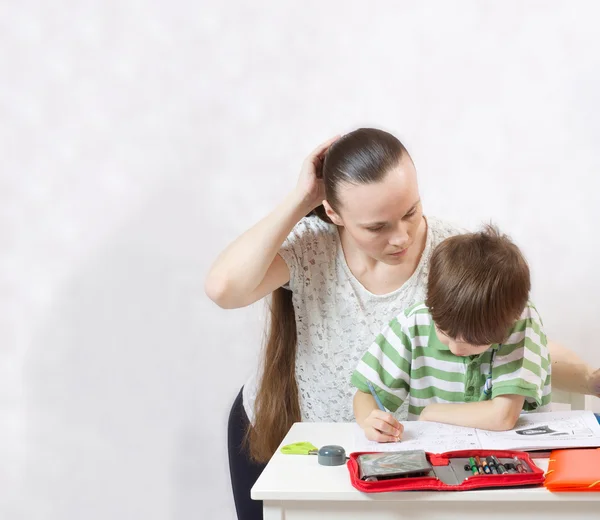 Die Mutter überprüft die Hausaufgaben ihres Sohnes — Stockfoto