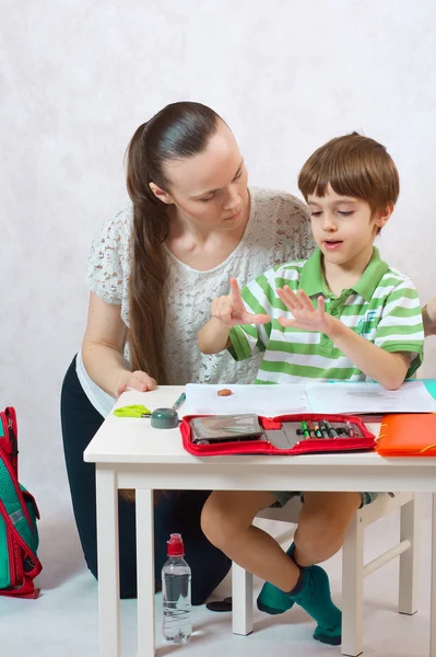 Die Mutter überprüft die Hausaufgaben ihres Sohnes — Stockfoto