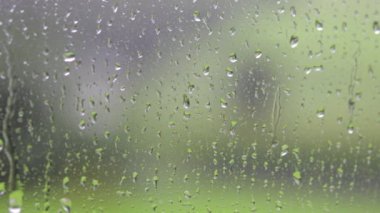 Cam pencereye yağmur damlaları düşer. Yakın çekim.
