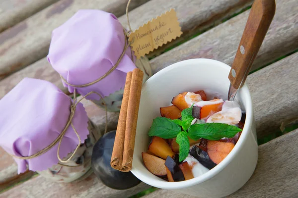 Yaourt maison avec des morceaux de prunes dans le plat blanc — Photo